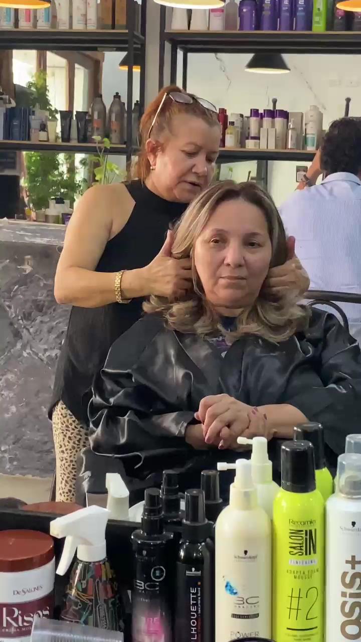 Estilista peinando a una clienta