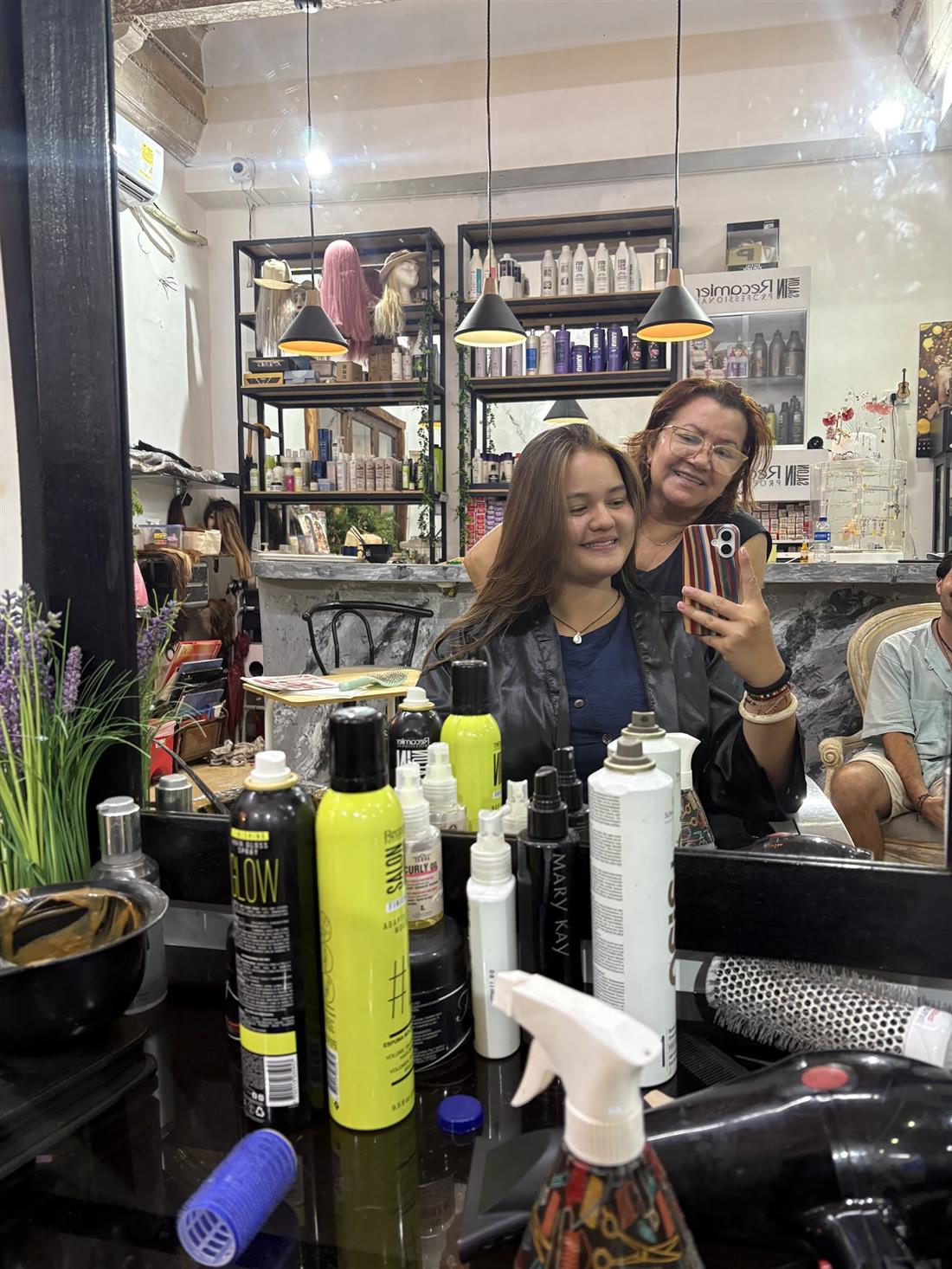 Clientas felices frente al espejo dentro del salón