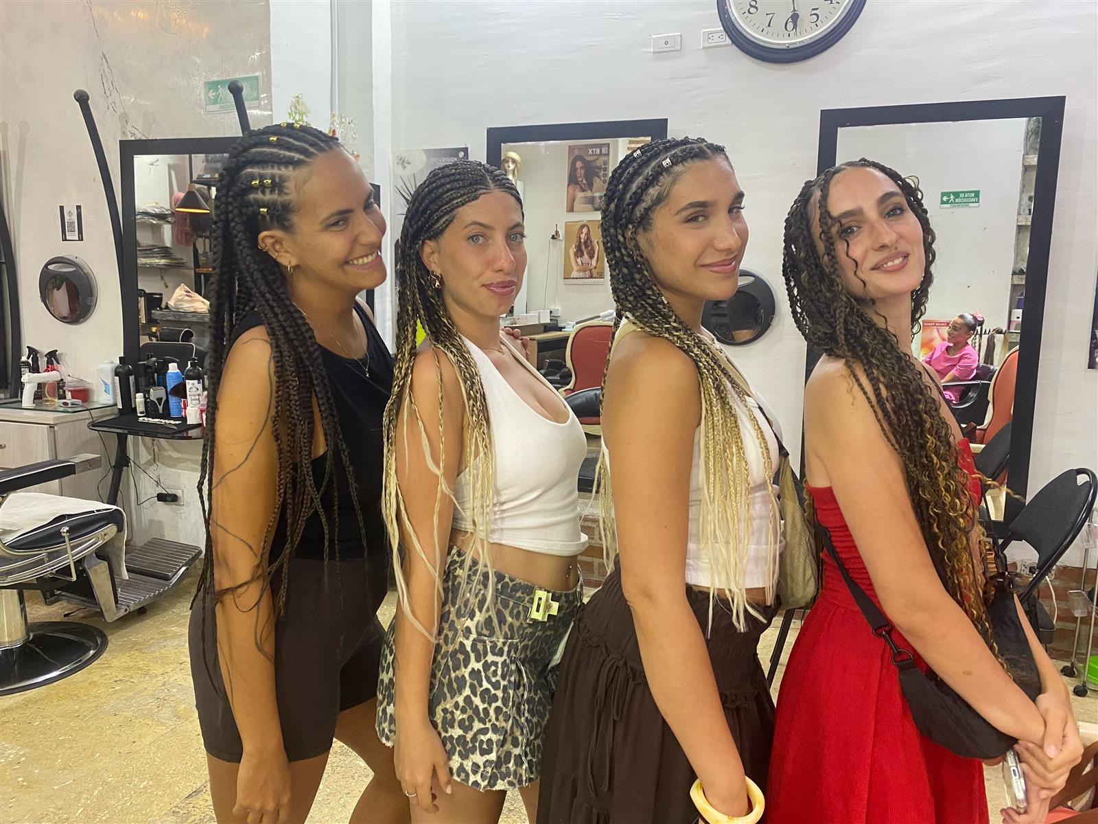 Cuatro amigas con trenzas recién hechas en el salón